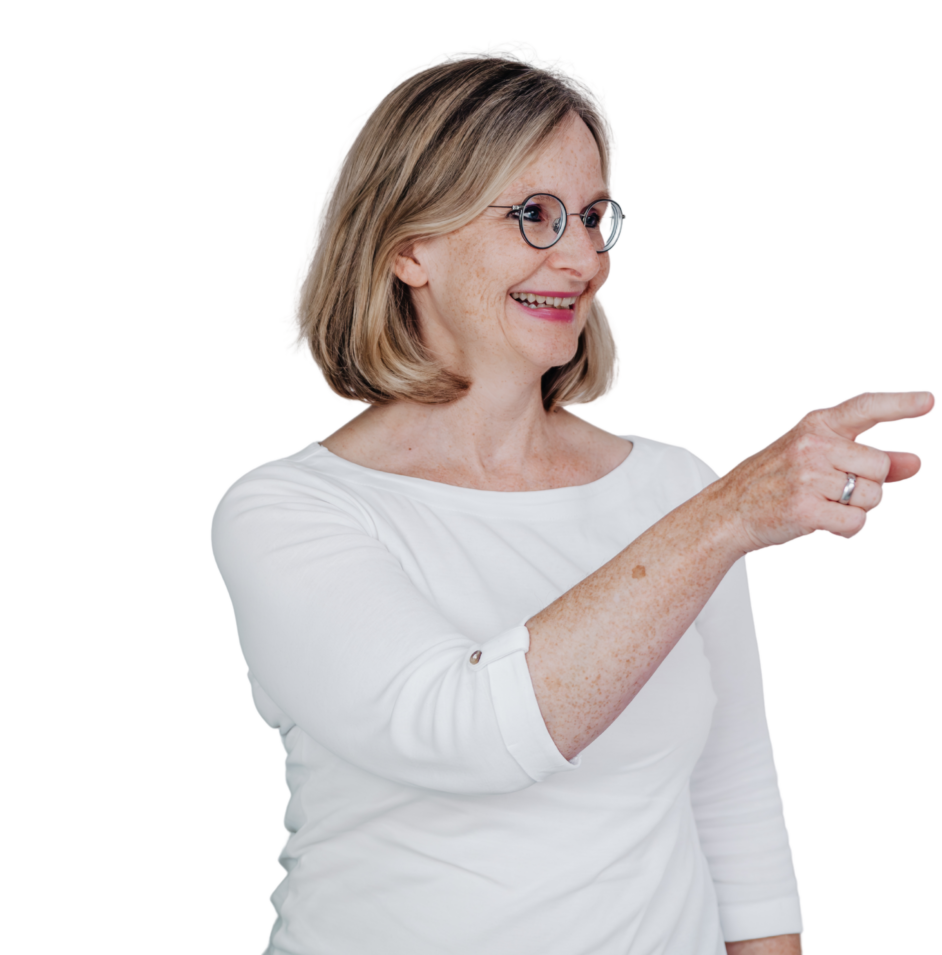 Eine Frau mit blonden Haaren und weißem Oberteil zeigt mit der Hand auf etwas.