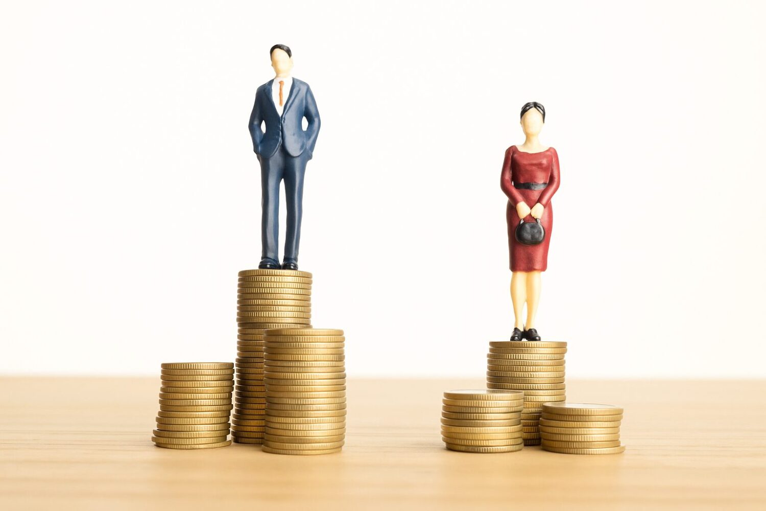 Bild eines Mannes der auf Geld steht neben einer Frau, die auf weniger Geld steht.